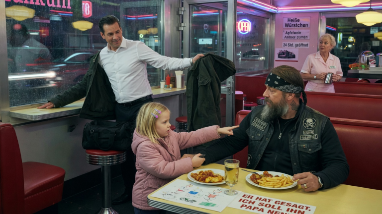 „ER HAT GESAGT, ICH SOLL IHN PAPA NENNEN“ — DAS KLEINE MÄDCHEN ZOG IM FRANKFURTER DINER AM ÄRMEL DES BIKERS, WÄHREND DER FREMDE AM FENSTER SEINE JACKE NAHM