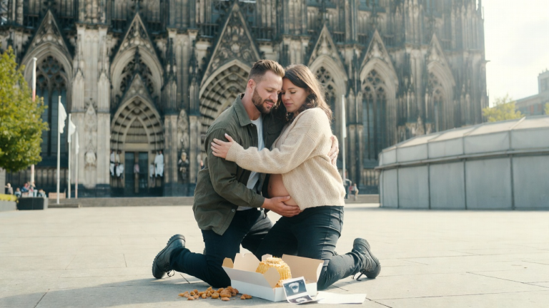 DER ÄLTERE BRUDER WARF DIE KUCHENSCHACHTEL VOR DEM KÖLNER DOM ZU BODEN, WEIL SEINE SCHWANGERE SCHWESTER NACH HAUSE GEKOMMEN WAR, OHNE DEN NAMEN DES VATERS DES KINDES ZU NENNEN. AUS DER SCHACHTEL FIELEN EIN ULTRASCHALLBILD UND EIN BRIEF IHRES VERSTORBENEN EHEMANNS. DIE GANZE FAMILIE ERSTARRTE; DER BRUDER UMARMTE SIE FEST, DAS GESICHT VOLLER REUE.
