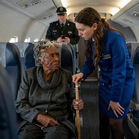 “They Sneered At Me For Being The Last Passenger On Board And Threatened To Have Me Removed By Force, Never Realizing My Family Actually Built This Entire International Terminal.”

I’ve spent sixty-five years teaching my children and grandchildren that kindness costs absolutely nothing, but as the last passenger stepped off Flight 442 from London to Atlanta, I realized that for some people, a lack of it was about to become very, very expensive.

The flight had been eleven hours of cramped, recycled air and the dull ache in my left hip that only seems to flare up when I’m thirty thousand feet above the Atlantic. I didn’t mind the wait; I’m a woman of patience. I sat in seat 14B, my hands folded over the handle of my cherrywood cane, watching the frantic scramble of humanity as everyone else fought to be the first person to stand in a line at Customs. I waited until the bridge was clear, until the overhead bins had stopped slamming, and until the silence of the cabin began to settle like dust.

I’m eighty-two years old. I don’t move like a gazelle anymore. My knees have a long-standing argument with gravity, and on this particular Tuesday, gravity was winning. I had requested a wheelchair assistance at the gate when I booked the ticket—my grandson, Marcus, had insisted on it—but as I looked toward the front of the plane, there was no chair waiting. There was only a young woman in a crisp blue uniform, her arms crossed tightly over her chest, and a pilot who looked like he’d rather be anywhere else on God’s green earth than on this aircraft.

“Ma’am?” the flight attendant called out. Her voice didn’t carry the warmth of hospitality. It carried the sharp, jagged edge of a woman who had already decided I was a nuisance. “We need you to deplane. Now. We have a turnaround in forty minutes and the cleaning crew is waiting.”

“I’m coming, dear,” I said, my voice steady despite the tremor in my hands. “I’m just waiting on the wheelchair I requested. My hip is a bit stubborn today.”

The flight attendant, whose name tag read ‘Tiffany,’ didn’t move to help. She didn’t offer a steadying hand. Instead, she turned to the pilot and sighed, a loud, theatrical sound that echoed through the empty rows. “There’s no wheelchair on the manifest, Ma’am. You’re going to have to walk it. We don’t have all day.”

I tried to stand, my fingers white-knuckled on the armrest. The pain shot through me like a bolt of lightning, forcing me back down into the thin padding of the seat. I let out a small gasp, a sound of genuine physical distress.

“Is there a problem?” the pilot asked, stepping forward. He didn’t look concerned. He looked offended. He looked at me as if I were a piece of malfunctioning equipment that was preventing him from getting to his hotel bar.

“I just need a moment,” I whispered. “Or some help. Please.”

“Look,” Tiffany said, walking down the aisle toward me. She didn’t stop until she was hovering over me, blocking out the dim light of the cabin. “We’ve had a long day. We’ve been in the air for twelve hours. We want to go home. You’re holding up the entire crew, and frankly, it’s selfish. If you can’t fly without being a burden, maybe you shouldn’t be flying at all.”

I looked up at her, really looked at her. I saw the impatience, the arrogance, and the total lack of empathy in her eyes. She saw a tired, elderly Black woman in a worn cardigan who was “taking up her time.” She didn’t see the woman who had put three kids through Ivy League schools. She didn’t see the woman whose family name was spoken in hushed, respectful tones in the boardrooms of this very city.

“I’m sorry you feel that way,” I said softly.

“I don’t care about your apology,” the pilot snapped from the front. “Tiffany, turn the lights off. Maybe the dark will help her find her motivation. I’m going to call security and have her removed for non-compliance. I’m done playing games.”

Then, the cabin went pitch black. The hum of the air conditioning died, leaving a suffocating, heavy heat in its place. I sat there in the dark, my heart hammering against my ribs, abandoned in a multi-million dollar machine by people who thought I was nothing.

They didn’t know that my son, Marcus, was currently standing in the VIP lounge of the Vance International Terminal—the terminal he had designed, built, and owned—waiting for the woman who had raised him to walk through those doors.

They didn’t know that in about five minutes, their world was going to come crashing down.

Read the full story in the comments.
If you don’t see the new chapter, tap ‘All comments’.