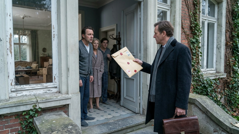 DIE FAMILIE SCHLEIFTE DIE ALTE MUTTER AM ARM AUS DEM WOHNZIMMER IN DEN KALTEN FLUR, DAMIT SIE ENDLICH INS PFLEGEHEIM KOMMT UND DIE VILLA VERKAUFT WERDEN KANN — DOCH AM NÄCHSTEN MORGEN STAND DER NOTAR MIT EINEM VERSIEGELTEN UMSCHLAG VOR DER TÜR.